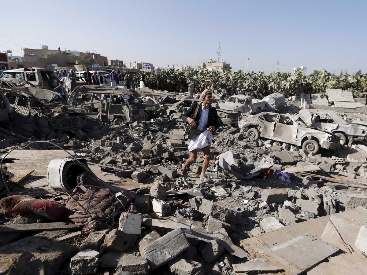A Yemeni man picks his way through rubble [Photo Credit: Khaled Abdullah/Reuters]
